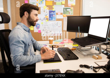 Side view of designer using digitizer and stylus on creative office desk Stock Photo