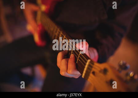Mid-section of man playing guitar in pub Stock Photo