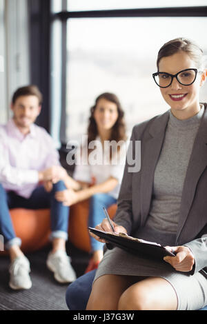 Portrait of smiling marriage counselor with couple in background Stock Photo