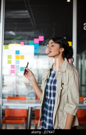Female executive smoking electronic cigarette in office Stock Photo