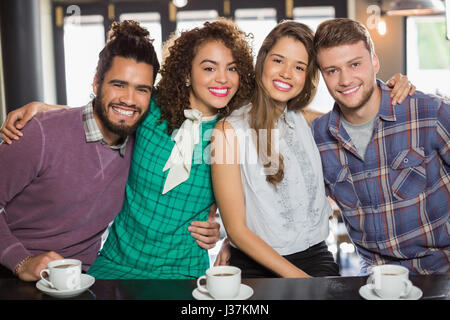 Portrait of cheerful friends sitting in cafe