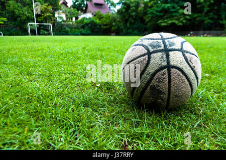 old used ball on green grass field Stock Photo