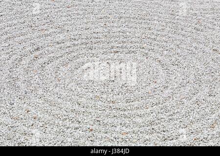 Circular raked gravel pattern in a zen garden Stock Photo