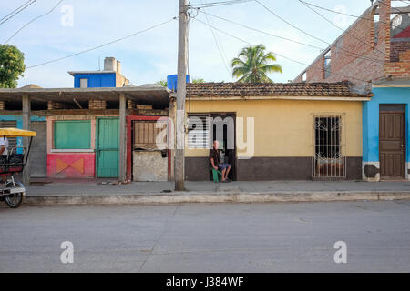 Local street life in Trinidad, Sancti Spiritus, Cuba. Man sitting alone on his doorstep. Stock Photo