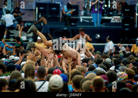 Concert goers crowd surf in the mosh pit in front of the main stage as ...