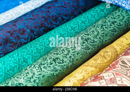 Rolls of fabric and textiles in a factory shop. Multi different colors and patterns on the market Stock Photo