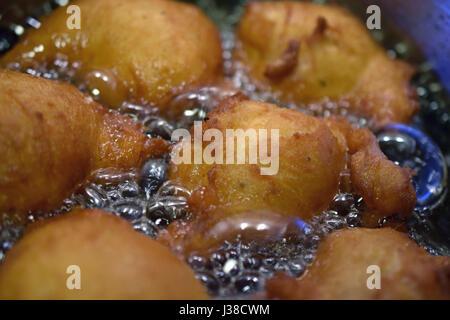 Donuts frying in hot oil. Stock Photo