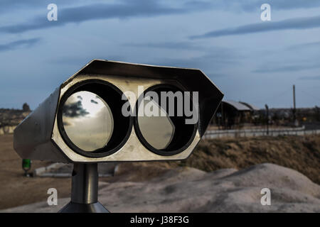 Touristic telescope look at the city with view of Göreme, town in Turkey. Close up old metal binoculars, coin operated telescope for panorama. Stock Photo