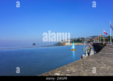 Tourists enjoying the April sun at Clevedon Marine Lake, Clevedon pier in the background Stock Photo