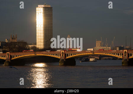 Millbank Tower glowing in the evening sun looking north across the River Thames and Vauxhall Bridge in London, England, United Kingdom. Once known as Vickers Tower. Stock Photo