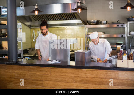Professional chefs working in commercial kitchen Stock Photo