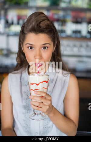 Portrait of young woman drinking smoothie at restaurant Stock Photo