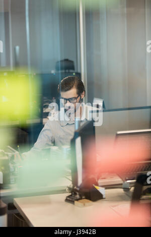 Concentrated businessman working at desk in office Stock Photo