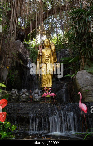 Golden Buddha statue and small artificial waterfall at the Golden Mount at Wat Saket in Bangkok, Thailand. Stock Photo