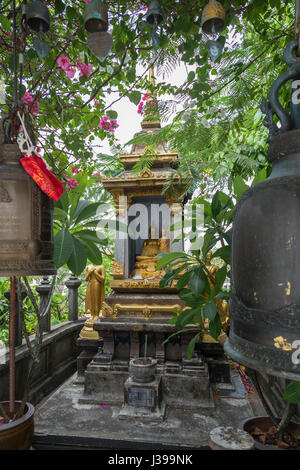 Golden Buddha statues and old bells at a small shrine at the Golden Mount at Wat Saket in Bangkok, Thailand. Stock Photo