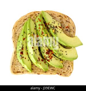 Open avocado sandwich with chia seeds and seasoning on whole grain bread isolated on a white background Stock Photo