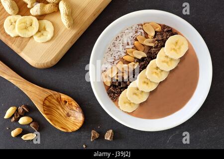 Chocolate peanut-butter banana, smoothie bowl downward scene on a slate background Stock Photo