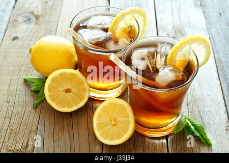 Two glasses of cold iced tea with lemon slices on a rustic wood background Stock Photo
