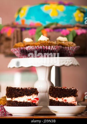 Delicious chocolate cake pieces with cream filling sitting on small plates, pastry concept Stock Photo