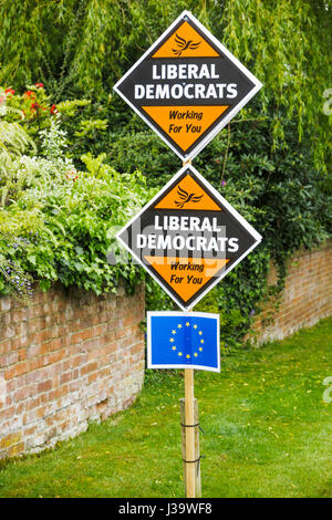 Roadside orange diamond-shaped boards, placards or signs on grass verge supporting and electioneering for the Liberal Democrat political party Stock Photo