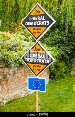 Roadside orange diamond-shaped boards, placards or signs on grass verge supporting and electioneering for the Liberal Democrat political party Stock Photo