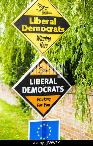 Roadside orange diamond-shaped boards, placards or signs on grass verge supporting and electioneering for the Liberal Democrat political party Stock Photo