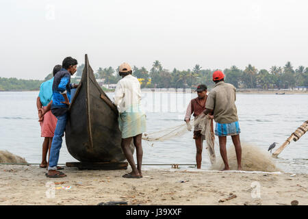 Keralan fishermen checking their nets on the shore in Kochi (Cochin), Kerala, South India, South Asia Stock Photo