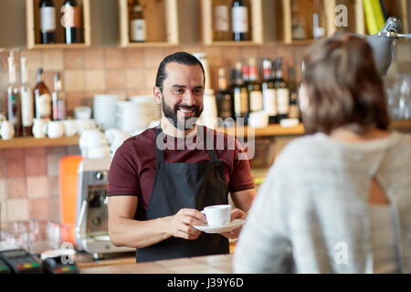 man or waiter serving customer in coffee shop Stock Photo