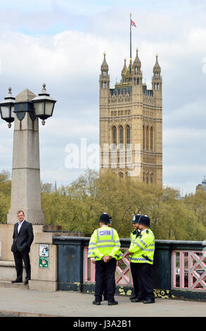 London, England, UK. Police officers on Lambeth Bridge, Houses of Parliament behind Stock Photo