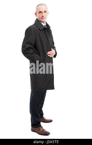 Side view of middle age elegant man posing wearing raincoat isolated on white background Stock Photo