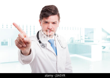 Serious doctor doing refusal or restriction gesture with copytext space Stock Photo