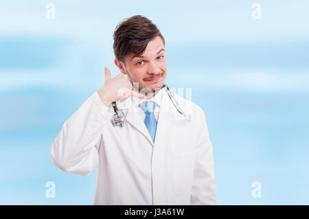 Portrait of charming medical doctor gesturing a call with his hands and smiling Stock Photo