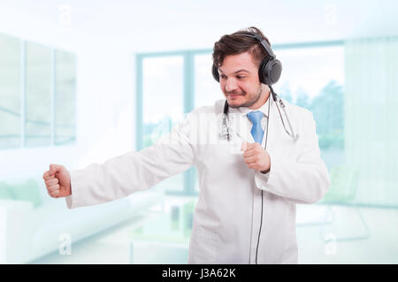Young doctor dancing with earphones on his head and relaxing Stock Photo