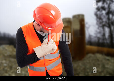 Young construction worker having chest pain or palpitation at working place Stock Photo