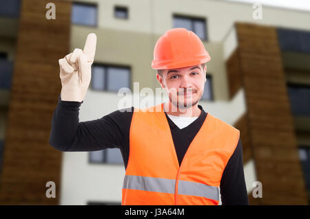 Cheerful builder pointing up his finger as new idea concept Stock Photo