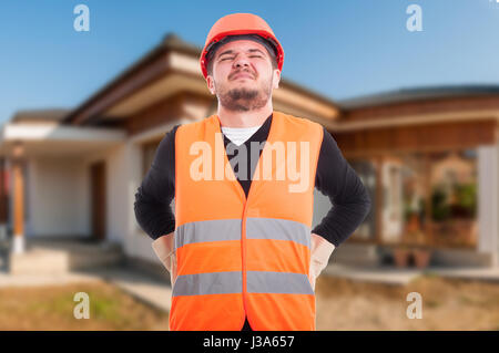Male engineer getting back injury after a long day of work at house renovation Stock Photo