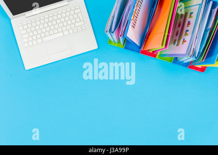 Blue office table with laptop and documents Stock Photo