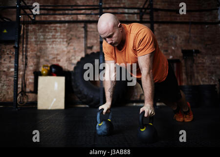 Doing Push-ups with Kettlebells Stock Photo