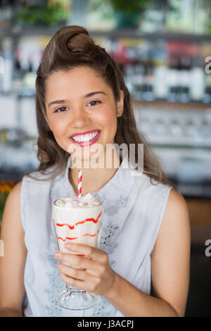 Portrait of beautiful young woman drinking smoothie at restaurant Stock Photo