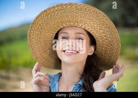Portrait of happy woman wearing sun hat with vineyard in background Stock Photo