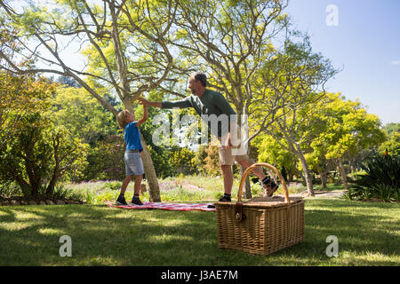 Father and son giving a high five while having picnic in the park Stock Photo