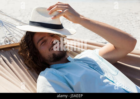 Portrait of smiling man relaxing in hammock on beach Stock Photo