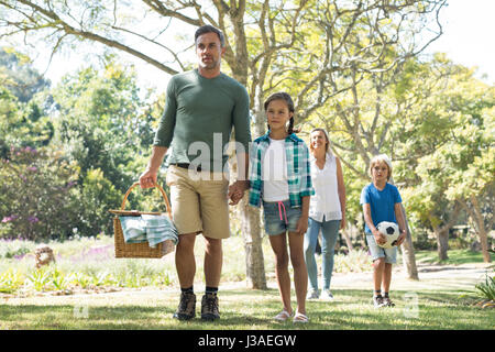 Family arriving in the park for picnic on a sunny day Stock Photo