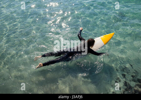 High angle view of surfer surfing in the sea on a sunny day Stock Photo