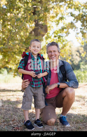 Portrait of happy elementary boy and father in forest Stock Photo