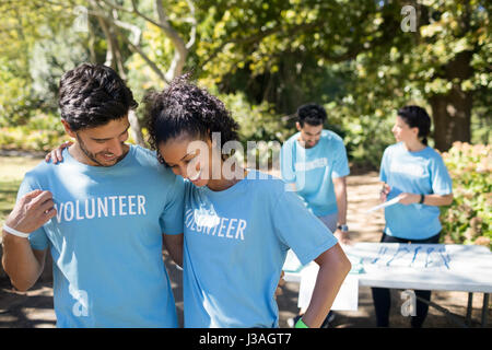 Smiling volunteers talking to each other in the park Stock Photo