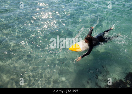 High angle view of surfer surfing in the sea on a sunny day Stock Photo