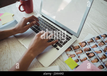 Cropped hands of female photo editor working on laptop in office Stock Photo