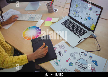 High angle view of female editor using digitizer on desk in office Stock Photo