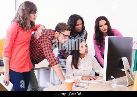 Business people working over desktop computer at desk in office Stock Photo